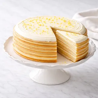 Tarta de crepes con crema en capas visibles, ideal para mesa de cumpleaños