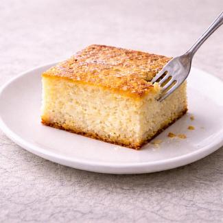A cut square of cottage cheese tray bake on a white plate
