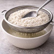 Cottage cheese in a sieve over a bowl,